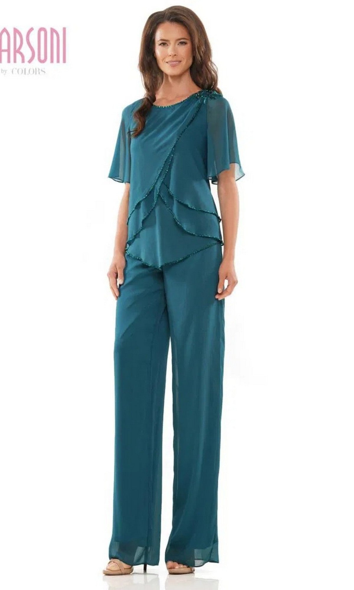 A woman wears the Marsoni M321 long formal teal pantsuit, featuring layered beaded detailing on the top, sheer short sleeves with beaded edges, and wide-leg pants.